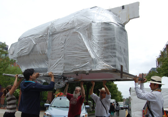 Jeff Del Papa of Waltham got help unloading his “Bedlam Express,” a giant belt-sander that he constructed at Artisan’s Asylum in Somerville. “There used to be belt-sander races in Somerville,” he said. “Artisan’s Asylum is all about getting tools in people’s hands. So building a big tool was an obvious thing.” (Greg Cook)