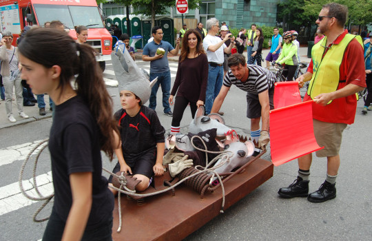 “It actually works. It’s locked, as you can see,” sculptor Eric Legacy (in striped shirt) of Stratham, New Hampshire, said of his giant, welded steel rattrap, which he raced with his family. “I made it a while ago as a statement about corporate development. They were chasing the artists out of Fort Point Channel like rats. … It’s pretty dangerous. It could take your arm off.” (Greg Cook)
